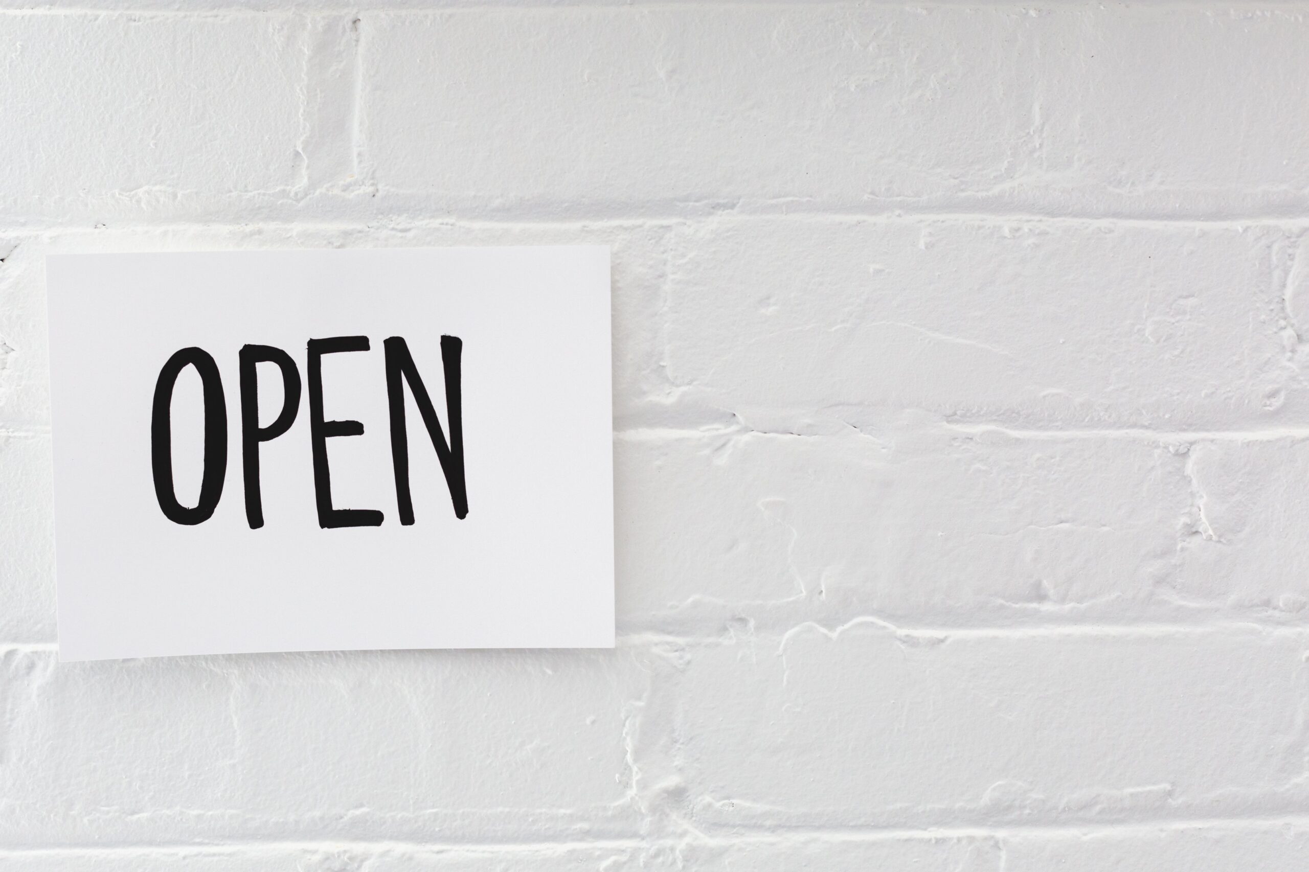 open sign on white brick